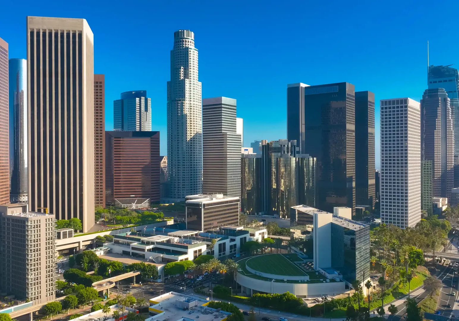 Skyline view of a sunny downtown city with modern skyscrapers and clear blue sky.