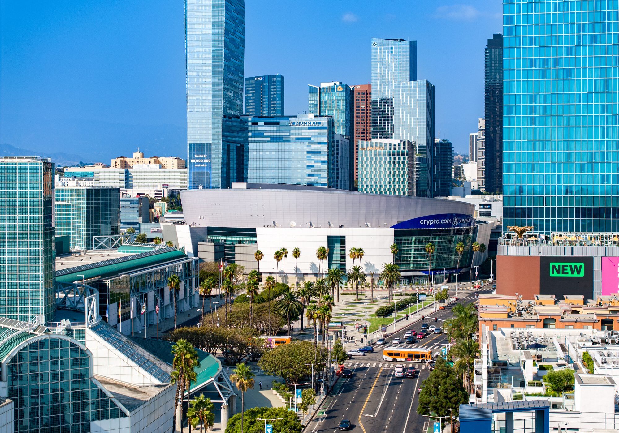 Modern cityscape with tall skyscrapers and busy streets under a clear blue sky.