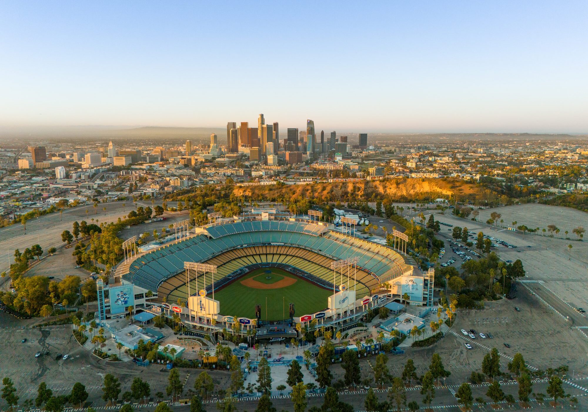 Aerial view of a baseball stadium with a city skyline in the background.