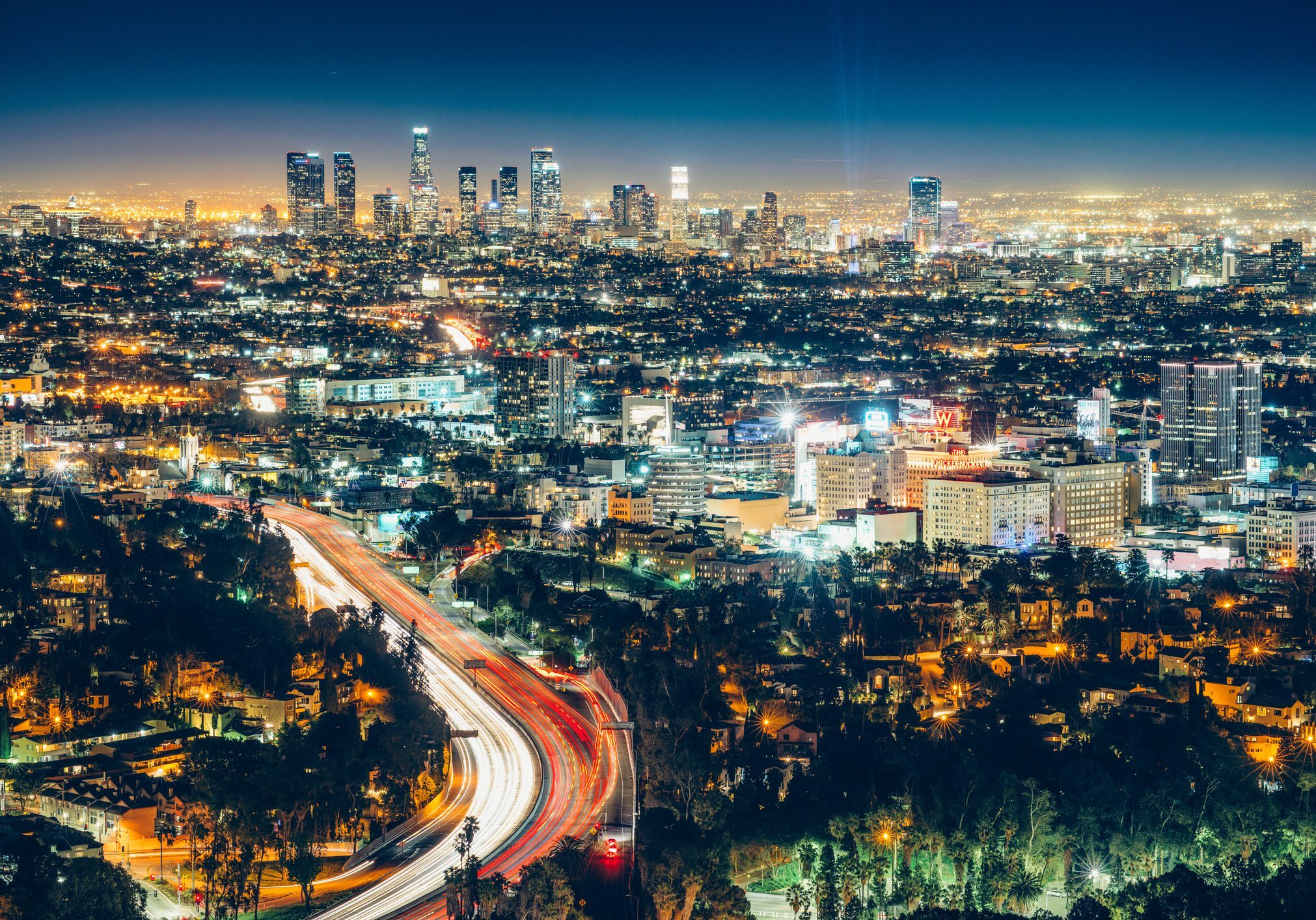 Nighttime cityscape with light trails from traffic.