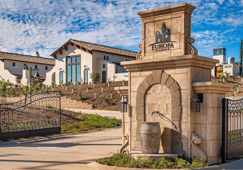 Entrance fountain and sign of The Terraces residential community under a blue sky.