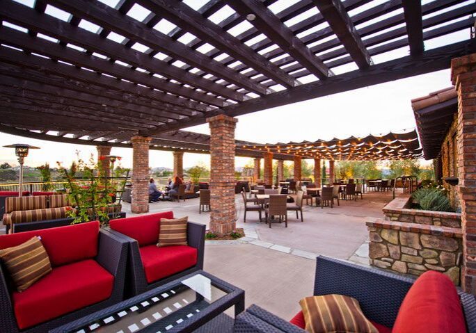 Outdoor lounge area with pergola and comfortable seating.